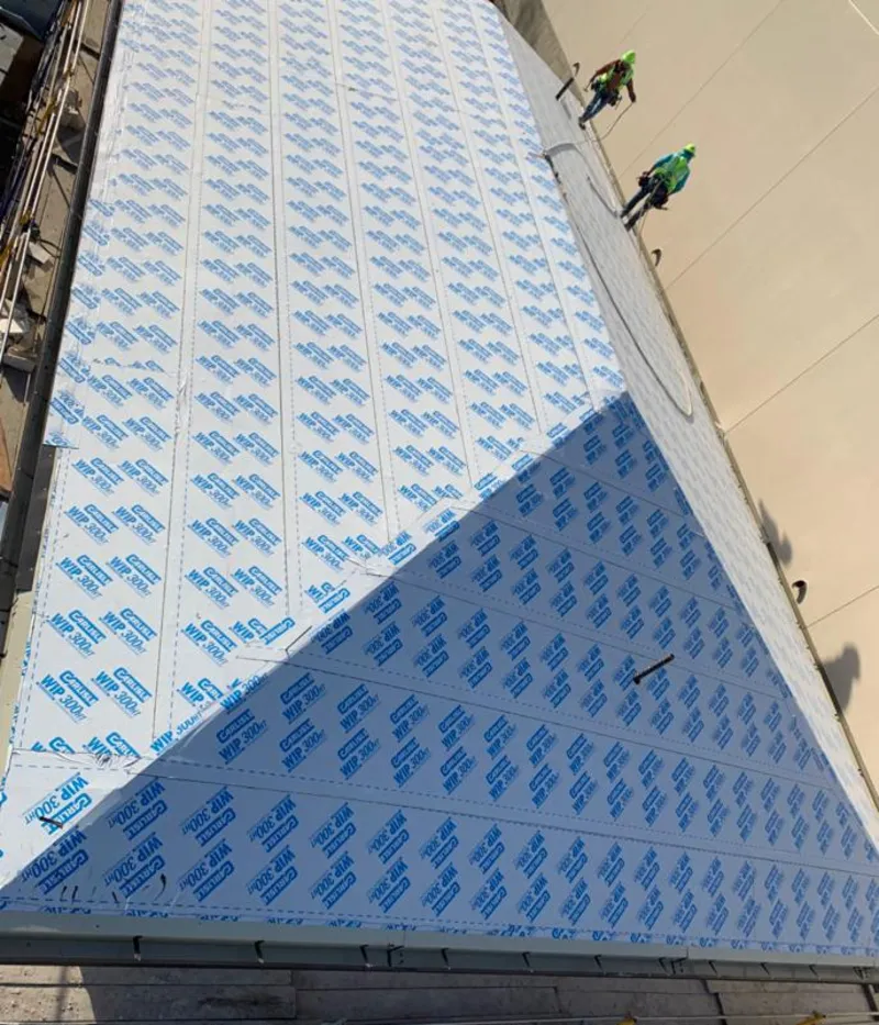 Professional roofers installing underlayment on a metal roof in North Miami